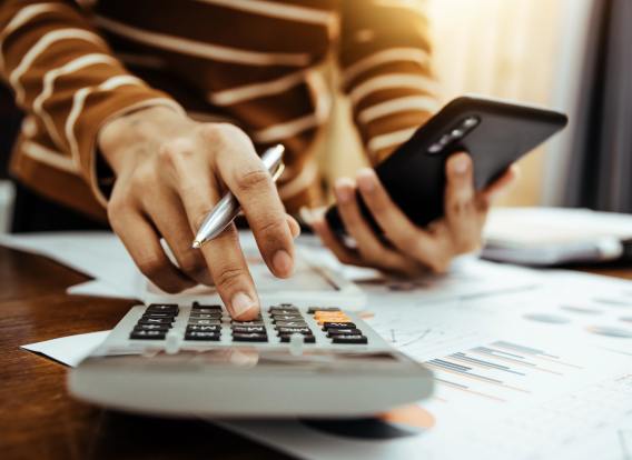 images of a person balancing a budget with a calculator.